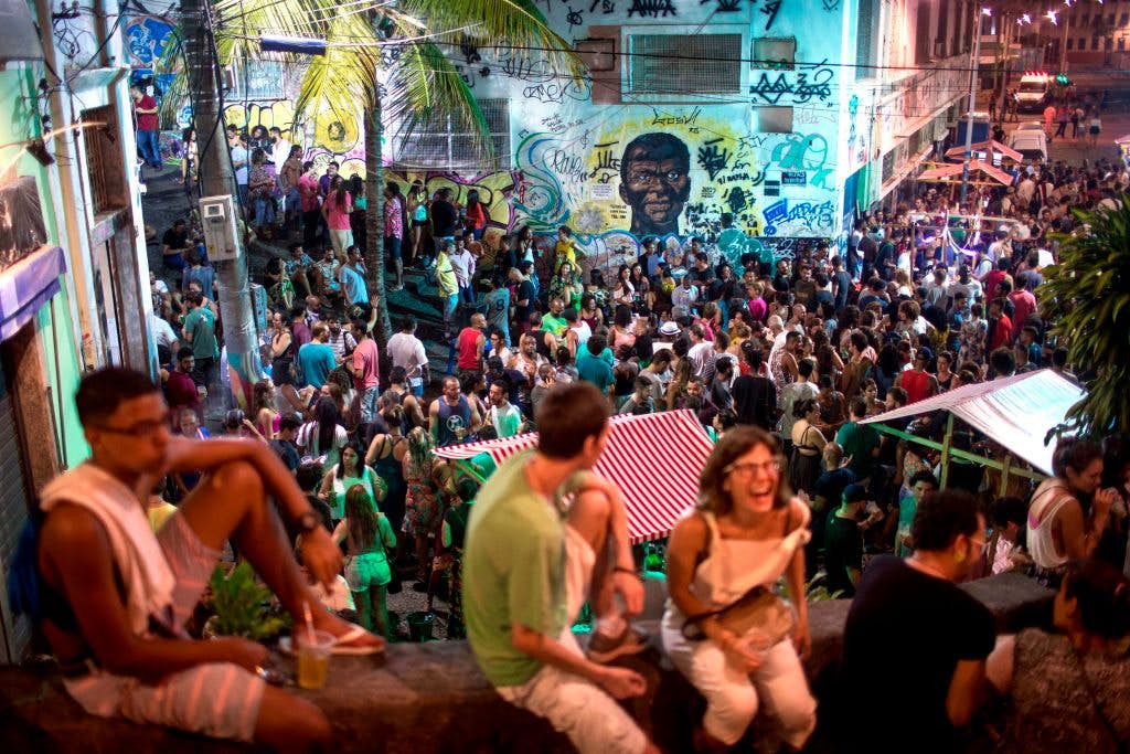 People attend a samba concert in the area of Quilombo Pedra do Sal, backdropped by a graffiti depicting Zumbi Dos Palmares - the main leader of Quilombo dos Palmares in Alagoas state during the colonial period and who became a symbol of the fight against slavery in the country- in downtown Rio de Janeiro, Brazil on December 18, 2017. .In Rio de Janeiro, three communities of descendants of slaves who broke chains from their masters cultivate the memory of their ancestral struggle. Unlike other "quilombos", they are amid the city and their current fight is against real estate speculation. / AFP PHOTO / MAURO PIMENTEL        (Photo credit should read MAURO PIMENTEL/AFP via Getty Images)
899383338
TOPSHOTS, Horizontal, CROWD, SAMBA, CONCERT, EFFIGY, SLAVERY
People attend a samba concert in the area of Quilombo Pedra do Sal, backdropped by a graffiti depicting Zumbi Dos Palmares - the main leader of Quilombo dos Palmares in Alagoas state during the colonial period and who became a symbol of the fight against slavery in the country- in downtown Rio de Janeiro, Brazil on December 18, 2017. In Rio de Janeiro, three communities of descendants of slaves who broke chains from their masters cultivate the memory of their ancestral struggle. Unlike other "quilombos", they are amid the city and their current fight is against real estate speculation. Rights managed: Full editorial rights UK, US, Ireland, Italy, Spain, Canada (not Quebec)
